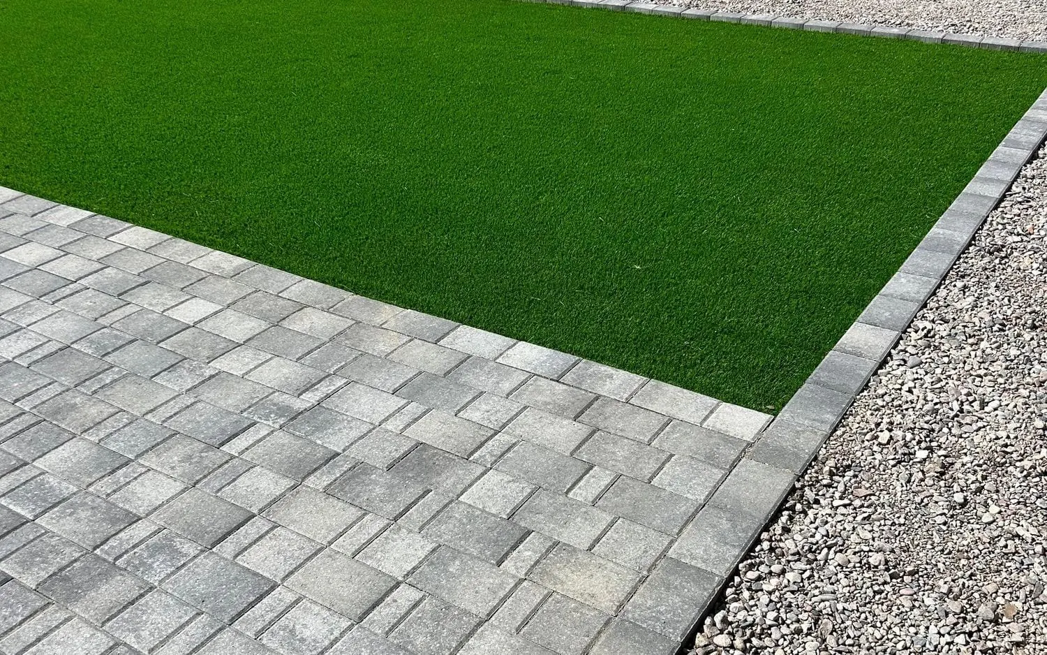Gray paver walkway next to artificial turf